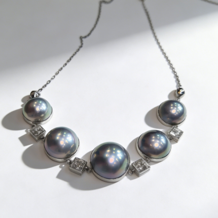 Luxury statement necklace featuring five large, silvery cool-toned seawater Mabe pearls from Amami Island, Japan, with square diamond accents on a silver-toned chain